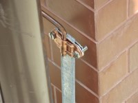 Прокладка медного токоотвода по водосточной трубе на углу здания и соединение его с заземляющим проводником
