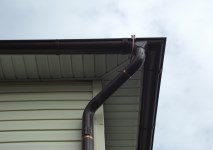 Соединение токоотвода с молниеприёмной сеткой и прокладка его по водосточной трубе на углу здания
